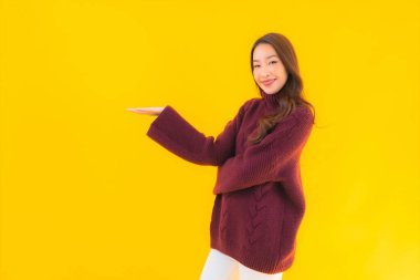 Güzel Asyalı kadın gülümsüyor. Sarı izole edilmiş arka planda başka bir eylemde mutlu.