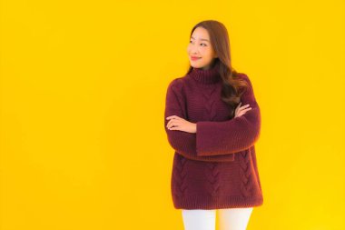 Güzel Asyalı kadın gülümsüyor. Sarı izole edilmiş arka planda başka bir eylemde mutlu.