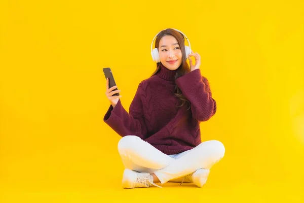 Portré Gyönyörű Fiatal Ázsiai Használ Okos Mobiltelefon Hallgatni Zenét Sárga — Stock Fotó