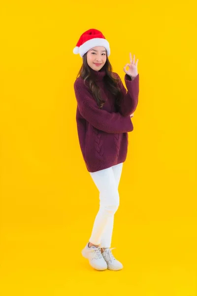 亚洲年轻貌美的女人穿着黄色孤立背景的圣诞装潢主题 — 图库照片