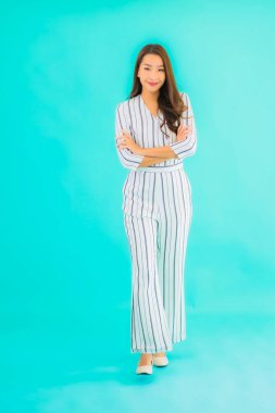 Asyalı güzel bir kadının portresi mavi izole edilmiş arka planda gülümsüyor.