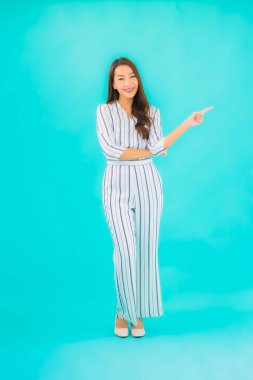 Asyalı güzel bir kadının portresi mavi izole edilmiş arka planda gülümsüyor.