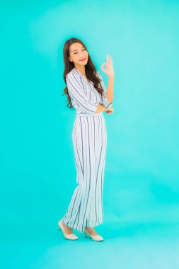 Asyalı güzel bir kadının portresi mavi izole edilmiş arka planda gülümsüyor.