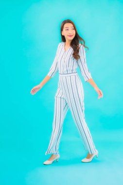 Asyalı güzel bir kadının portresi mavi izole edilmiş arka planda gülümsüyor.