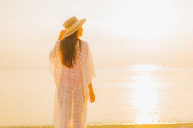 Güzel bir Asyalı kadın portresi. Rahatlayın. Güneşin batışında açık deniz okyanusunda rahatça gülümseyin.