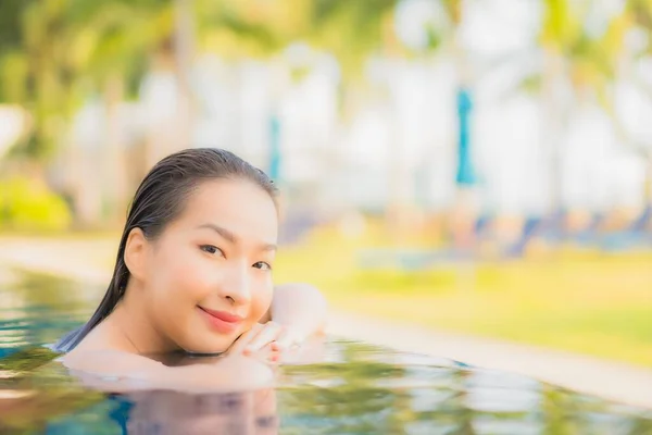 美しい若いアジアの女性は 休暇のための日没時に海のビーチの海の近くの屋外スイミングプールの周りの笑顔のレジャーをリラックス — ストック写真
