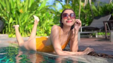 Güzel bir Asyalı kadın portresi otel havuzunda rahatça yüzebiliyor.