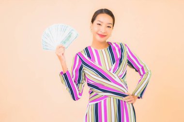 Parası, parası ve cep telefonu olan güzel Asyalı bir kadının portresi.