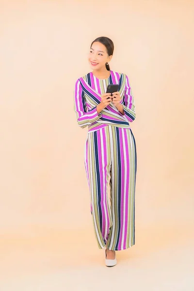 亚洲年轻貌美的女性在色彩隔离的背景下使用智能手机 — 图库照片