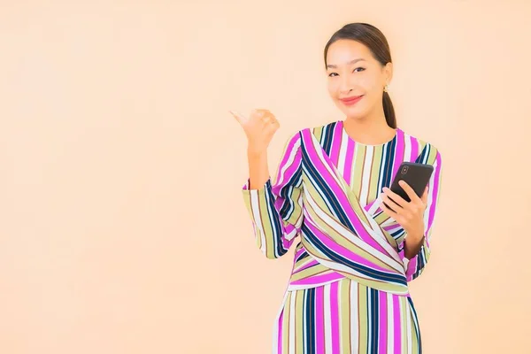 아름다운 아시아 여성의 초상화는 컬러로 배경에서 스마트폰을 — 스톡 사진