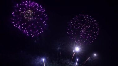 Gece gökyüzünde patlayan havai fişeklerin yakın çekim görüntüleri.
