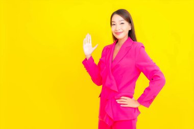 Güzel bir Asyalı kadın sarı arka planda gülümsüyor.