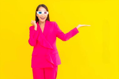 Güzel bir Asyalı kadın, sarı izole edilmiş arka plandaki film için 3D gözlük takıyor.