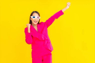 Güzel bir Asyalı kadın, sarı izole edilmiş arka plandaki film için 3D gözlük takıyor.