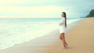 Deniz kıyısındaki güzel Asyalı genç kadının görüntüleri.