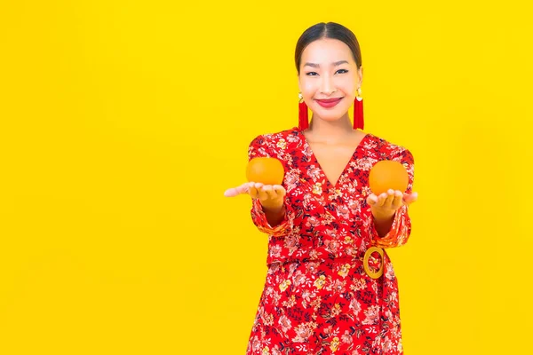 Sarı Arka Planda Turuncu Meyveli Güzel Asyalı Kadın Portresi — Stok fotoğraf