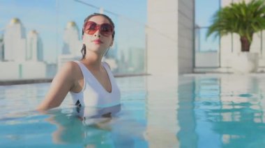 Havuzda dinlenen güzel bir Asyalı genç kadının görüntüleri.