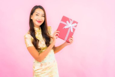 Pembe arka planda kırmızı hediye kutusu olan güzel bir Asyalı kadın portresi.