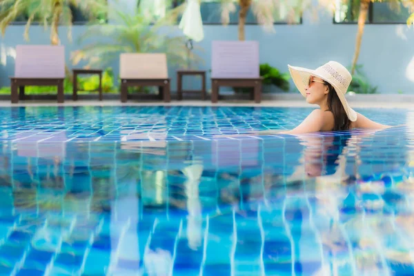 ポートレート美しい若いアジアの女性は休暇中のレジャーのためにホテルのリゾートでスイミングプールの周りリラックス — ストック写真