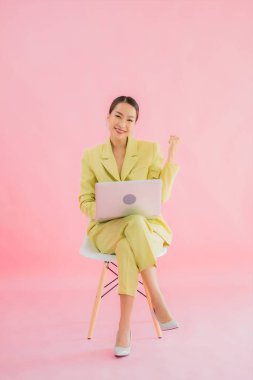 Güzel Asyalı iş kadını portresi renk arkaplanda bilgisayar bilgisayarı kullanıyor