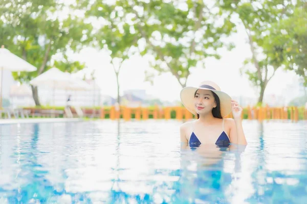 在度假胜地的室外游泳池边 年轻美丽的亚洲女人在度假旅行时 放松地笑着 — 图库照片