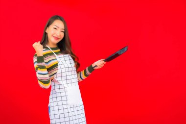 Kırmızı arka planda yemek pişirmeye hazır güzel Asyalı kadın portresi.