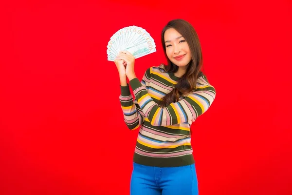 Portret Pięknej Młodej Azjatyckiej Kobiety Gotówką Telefonem Komórkowym Czerwonym Tle — Zdjęcie stockowe