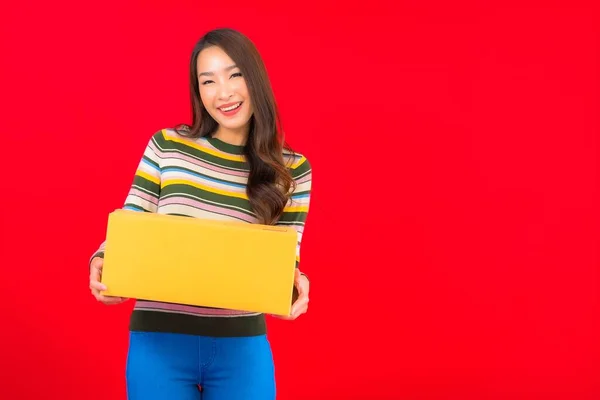 Porträt Schöne Junge Asiatische Frau Mit Paketkasten Auf Rotem Isolierten — Stockfoto