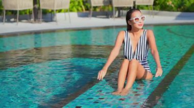 Havuzda dinlenen güzel bir Asyalı genç kadının görüntüleri.