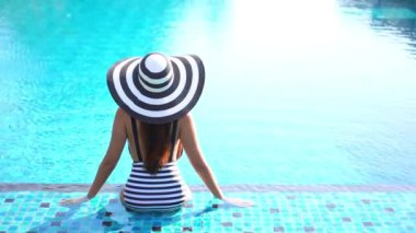 Havuzda dinlenen güzel bir Asyalı genç kadının görüntüleri.