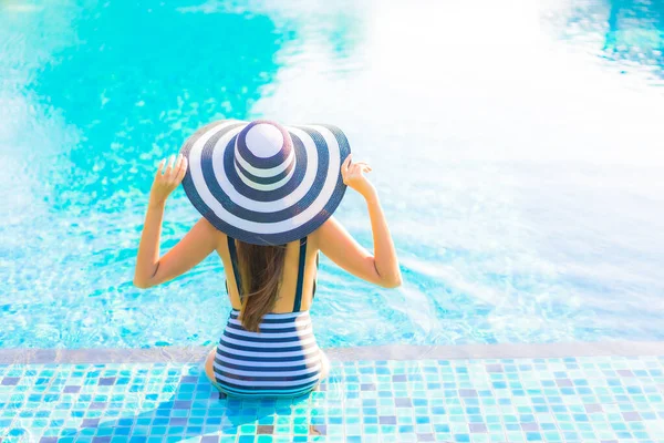 아름다운 여성이 리조트 수영장에서 휴가를 보내며 미소짓는 여가를 즐긴다 — 스톡 사진