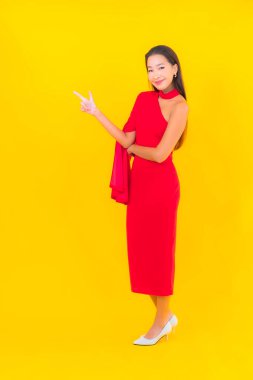 Güzel bir Asyalı kadın portresi. Sarı izole edilmiş arka planda hareketli gülümsüyor.