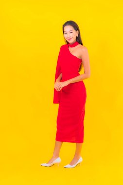 Güzel bir Asyalı kadın portresi. Sarı izole edilmiş arka planda hareketli gülümsüyor.