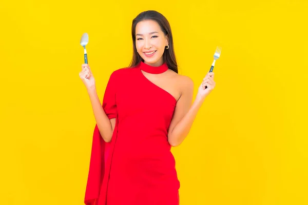 Çatal Kaşıkla Sarı Arka Planda Yemeye Hazır Güzel Asyalı Kadın — Stok fotoğraf