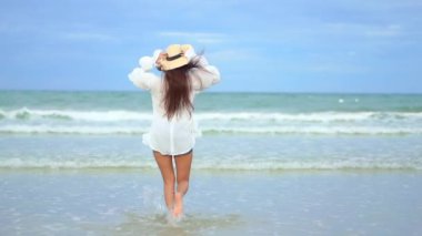 Güzel Asyalı kadının yaz tatilinde deniz kıyısında dinlendiği görüntüler.