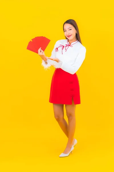 亚洲年轻貌美的女子 背景为黄色 用中文写着红包 — 图库照片