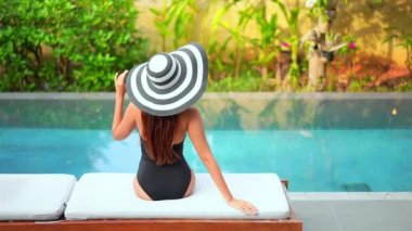 Güzel Asyalı kadının yaz tatilinde deniz kıyısında dinlendiği görüntüler.