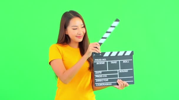 Кадры Молодой Азиатки Жёлтой Футболке Держащей Кинематограф Зелёном — стоковое видео