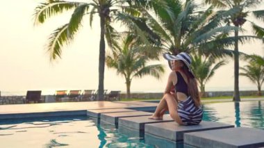 Güzel Asyalı kadının yaz tatilinde deniz kıyısında dinlendiği görüntüler.