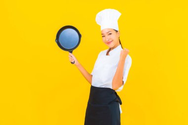 Sarı izole arka planda siyah şapkalı güzel Asyalı şef kadın portresi.