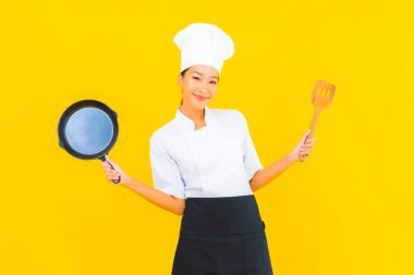 Sarı izole arka planda siyah şapkalı güzel Asyalı şef kadın portresi.