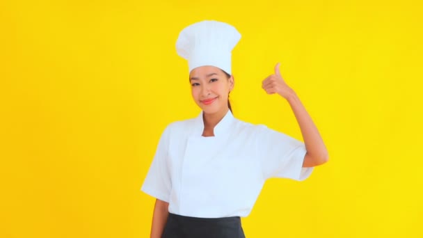 Portret Pięknej Młodej Azjatyckiej Kucharki Pokazujący Kciuk Górę Żółtym Tle — Wideo stockowe