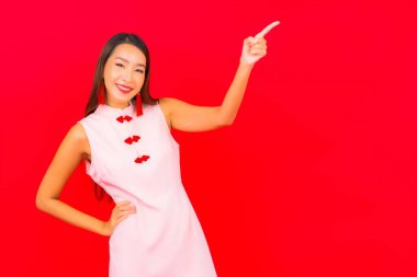 Güzel bir Asyalı kadın portresi kırmızı arka planda Çin 'e özgü yeni yıl kıyafetleri giyiyor.