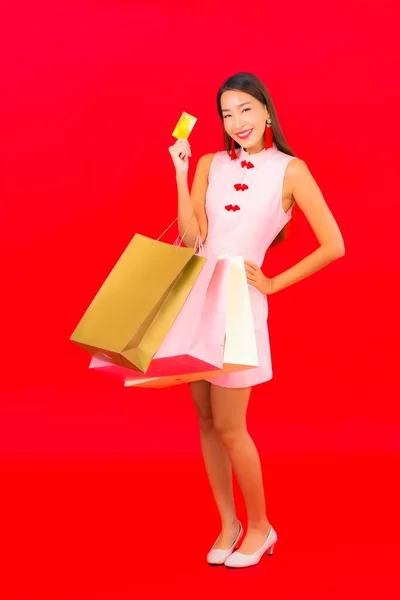 色彩艳丽的年轻亚洲女人 背负着红色孤立背景的购物袋 — 图库照片