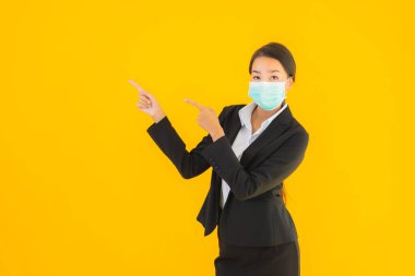 Güzel genç iş kadını portresi Korunmak için maske takıyor 19 koronavirüs sarı izole arka planda