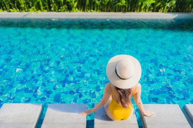Güzel bir Asyalı kadın portresi. Rahatlayın. Keyifli bir tatil için oteldeki yüzme havuzunda mutlu bir gülümseme.