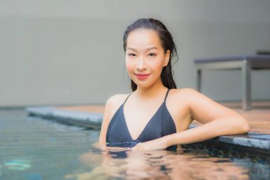 Güzel bir Asyalı kadının portresi. Gülümse. Yüzme havuzunda rahatla.