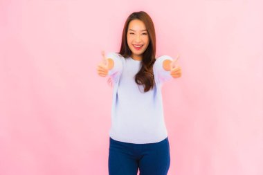 Portrait beautiful young asian woman smile with action on pink isolated background