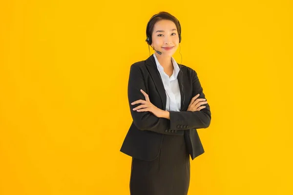 带有耳机或耳机的形象漂亮的年轻亚洲商人妇女 供呼叫中心或在黄色孤立背景下进行电话推销 — 图库照片