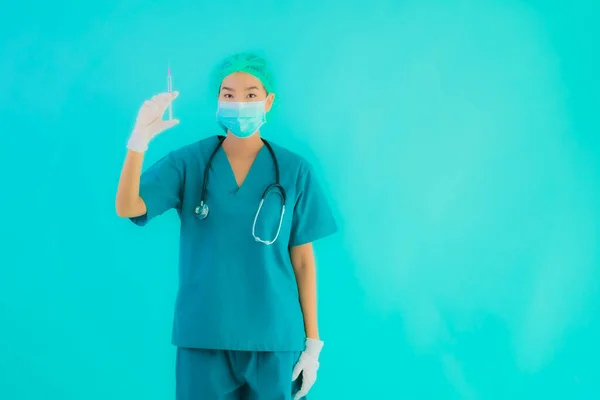 ポートレート美しい若いアジアの医師の女性は 青い隔離された背景にCoid19またはコロナウイルスから保護するための注射器ワクチンとマスクを着用 — ストック写真